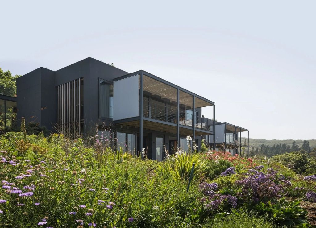 Moderne Architektur eines Boutique-Hotelgebäudes mit üppiger Vegetation im Vordergrund