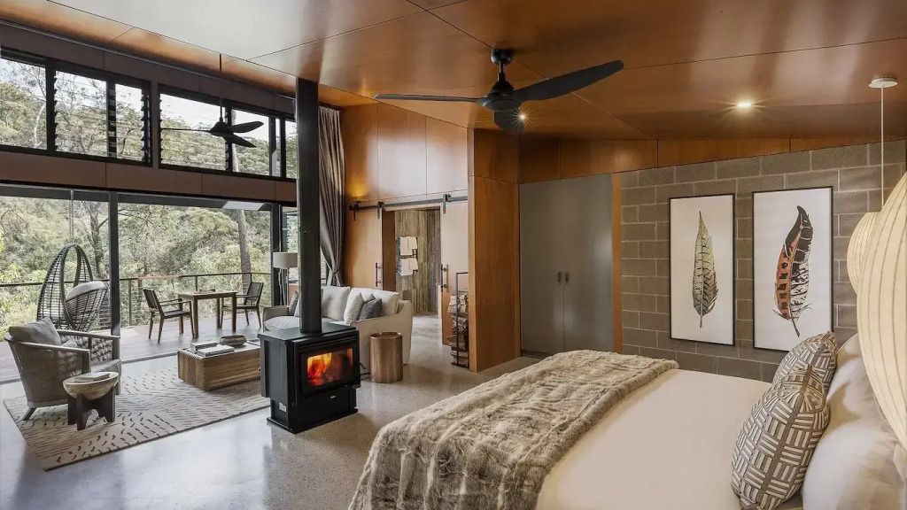 Gemütliche Suite mit Kamin, Sitzbereich und Balkon mit Blick ins Grüne.