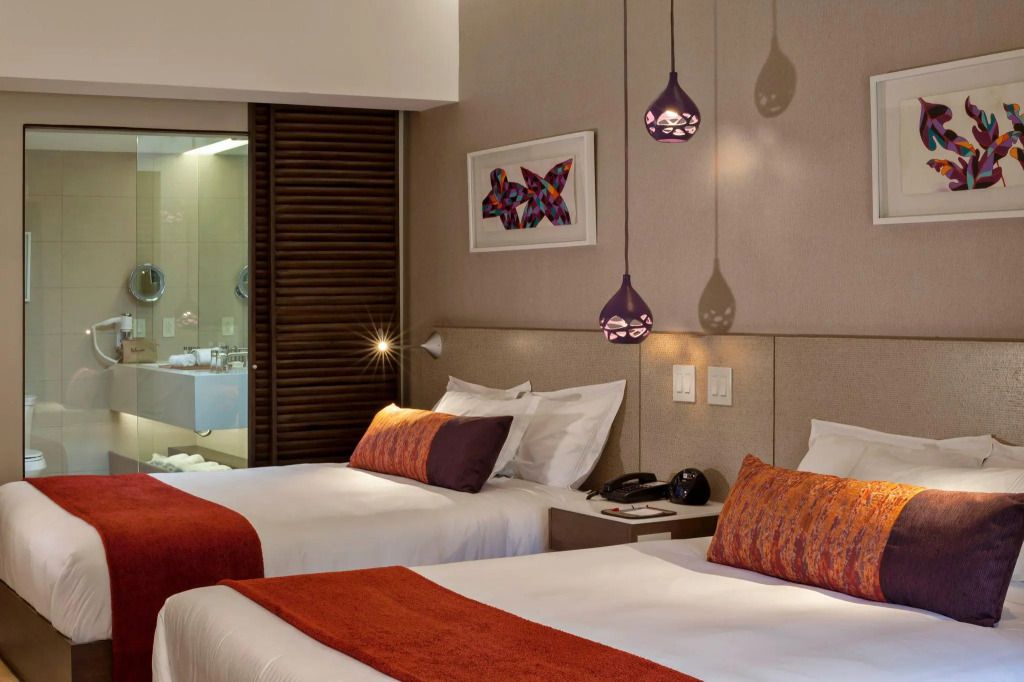 Modernes Hotelzimmer mit zwei Betten und stilvollen Hängelampen