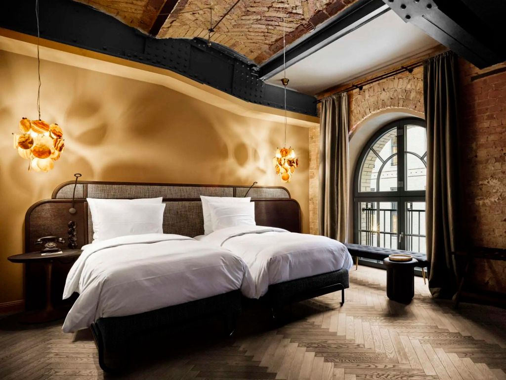 Elegantes Hotelzimmer mit Zwillingsbetten in einem loftartigen Raum