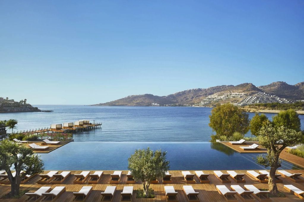 Infinity Pool mit Blick auf das Meer und umliegende Berge