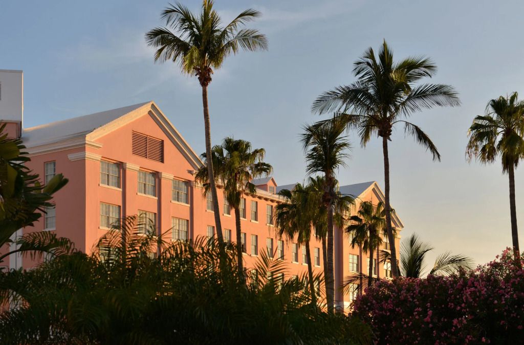 Elegante Fassade des Hotels bei Sonnenuntergang mit Palmen im Vordergrund