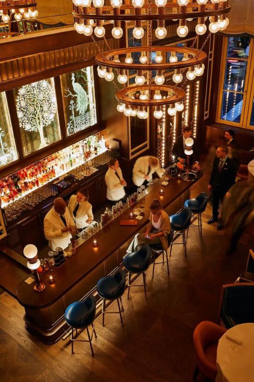 Elegante Hotelbar mit Barkeepern und Gästen am Abend