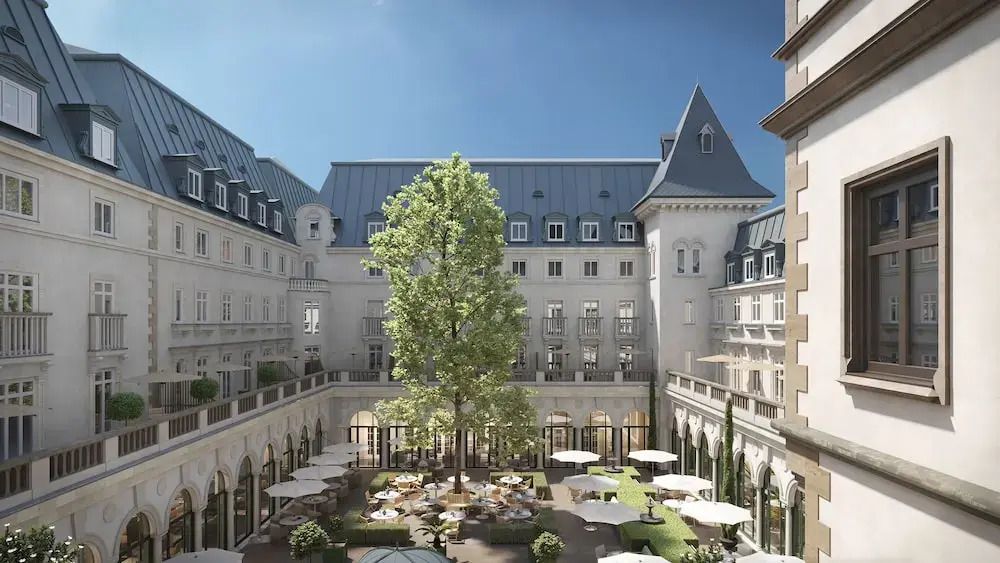 Hof im Innenbereich eines eleganten Hotels mit Terrassen und zentralem Baum