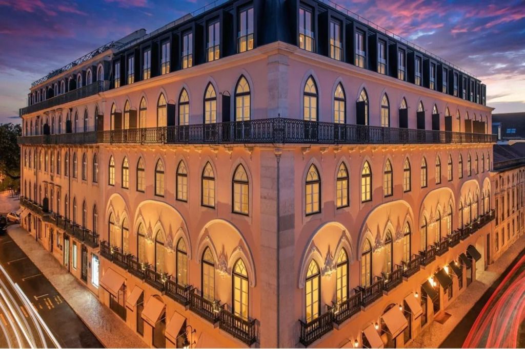 Historische Fassade des Hotels bei Abenddämmerung mit beleuchteten Fenstern