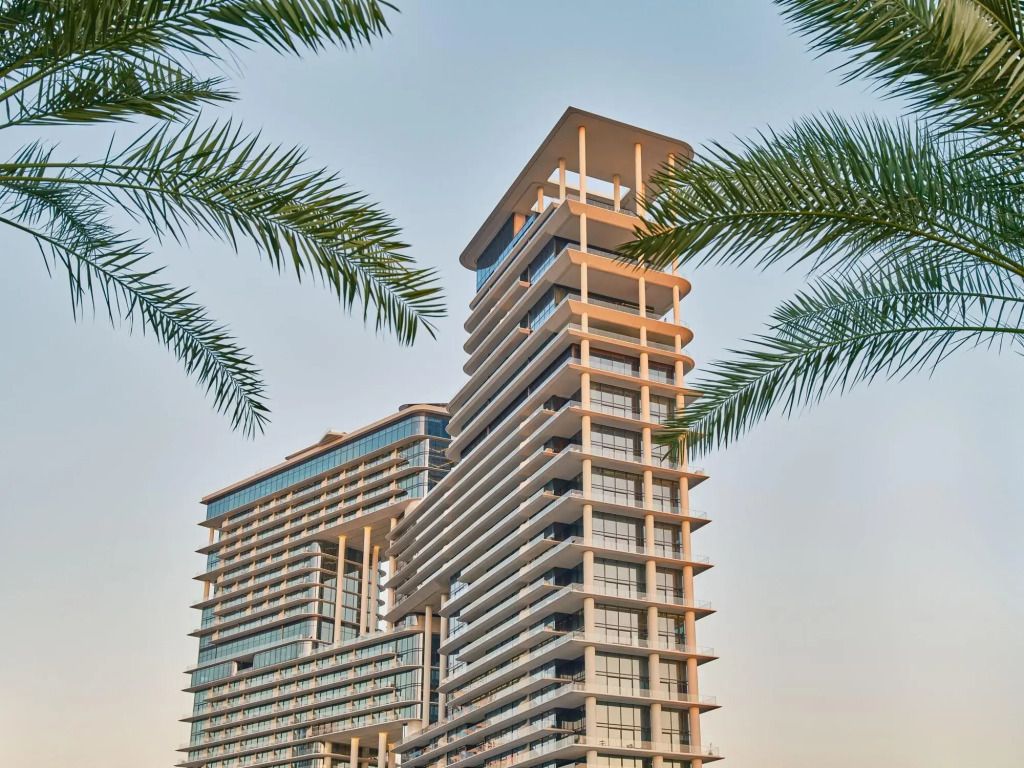 Moderne Hotelfassade umgeben von Palmen mit zwei eleganten Türmen