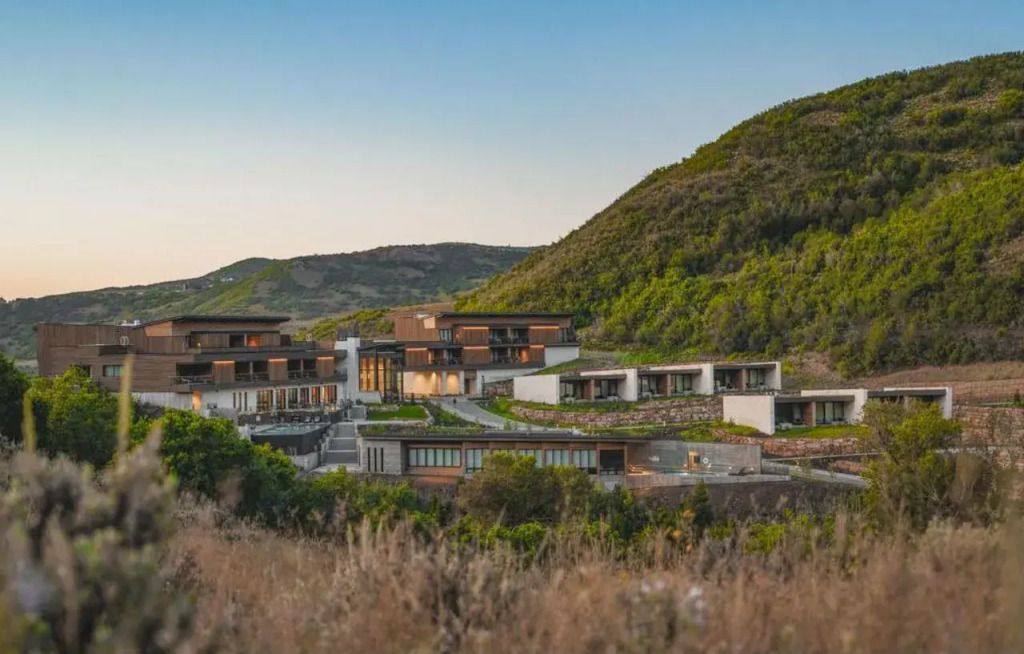Luxuriöses Hotel vor einer Bergkulisse bei Sonnenuntergang