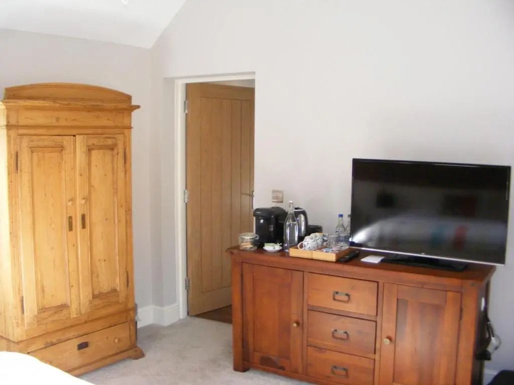 Hotelzimmer mit Holzmöbeln und Fernseher