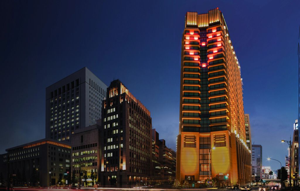 Leuchtende Fassade des The Peninsula Tokyo bei Nacht mit Skyline.