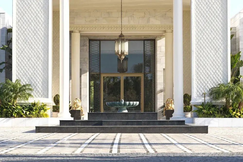 Eleganter Hoteleingang mit großen Säulen und zwei Löwenstatuen.