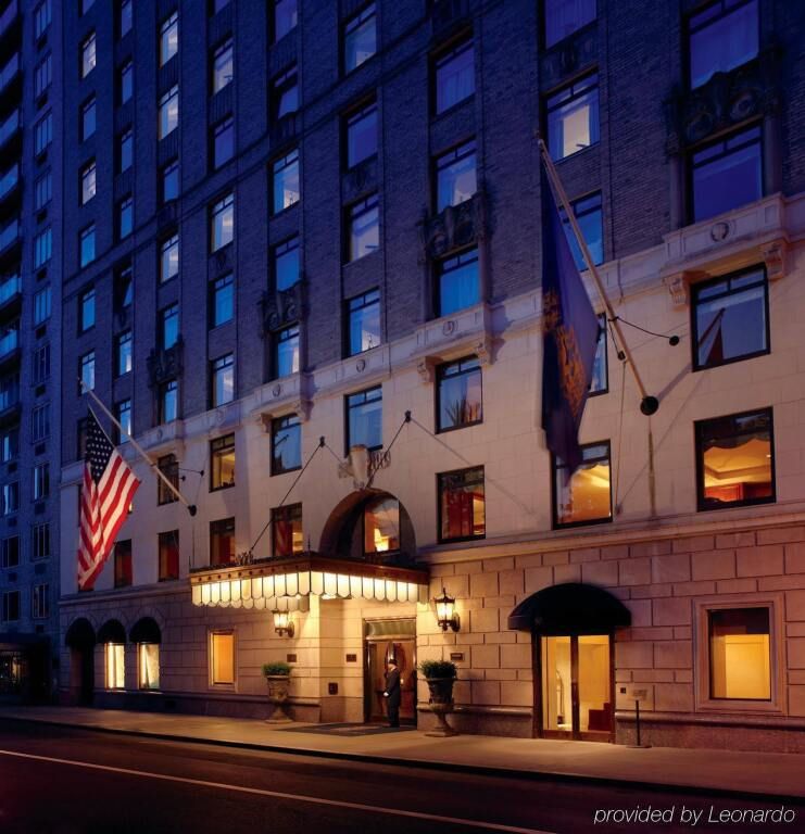 Fassade des Ritz-Carlton New York am Abend beleuchtet mit Flaggen