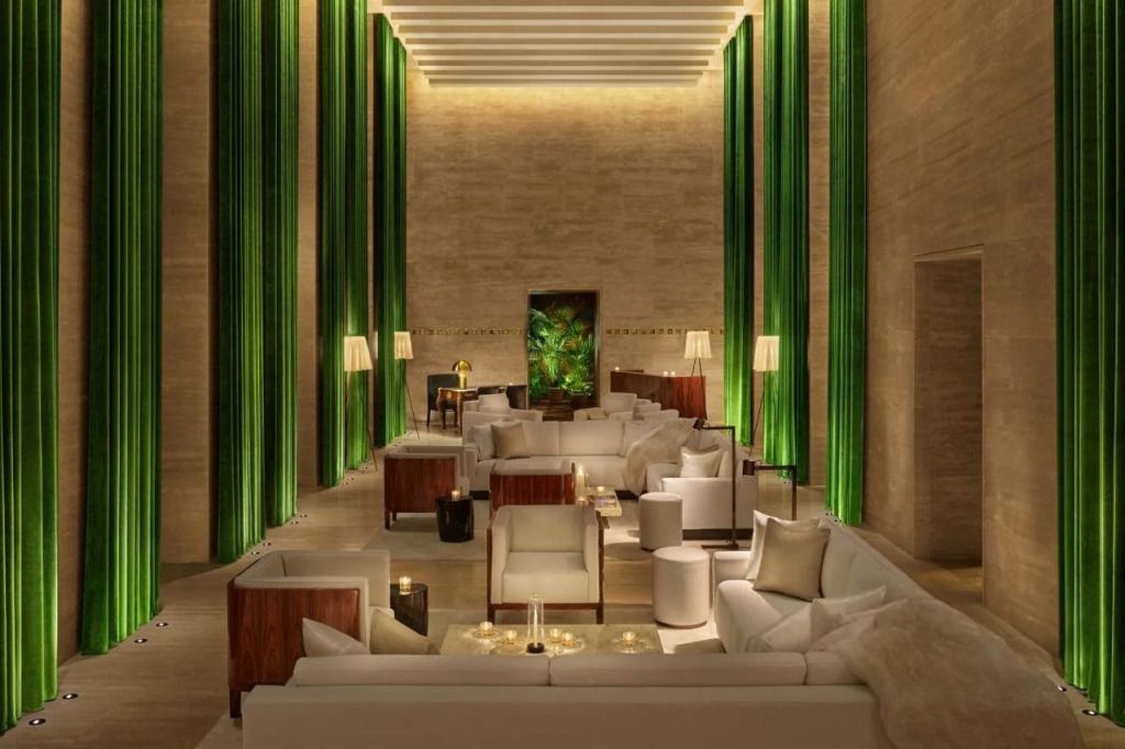 Elegante Lounge mit modernen weißen Sofas und hohen grünen Vorhängen