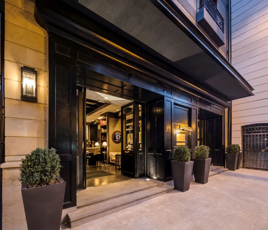 Elegante Hotelfassade mit stilvollem Eingang und Pflanzen.