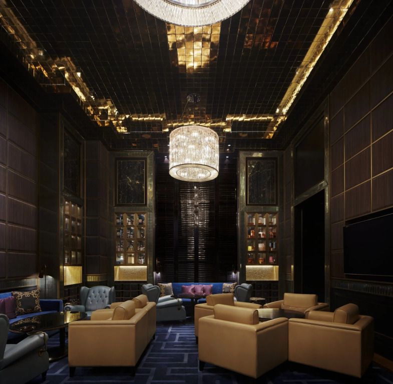 Luxuriöse Lounge mit goldenen Akzenten und Kronleuchter im St. Regis Kuala Lumpur