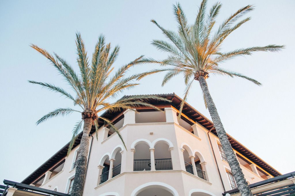 Außenfassade des St. Regis Mardavall mit Palmen und blauem Himmel im Hintergrund