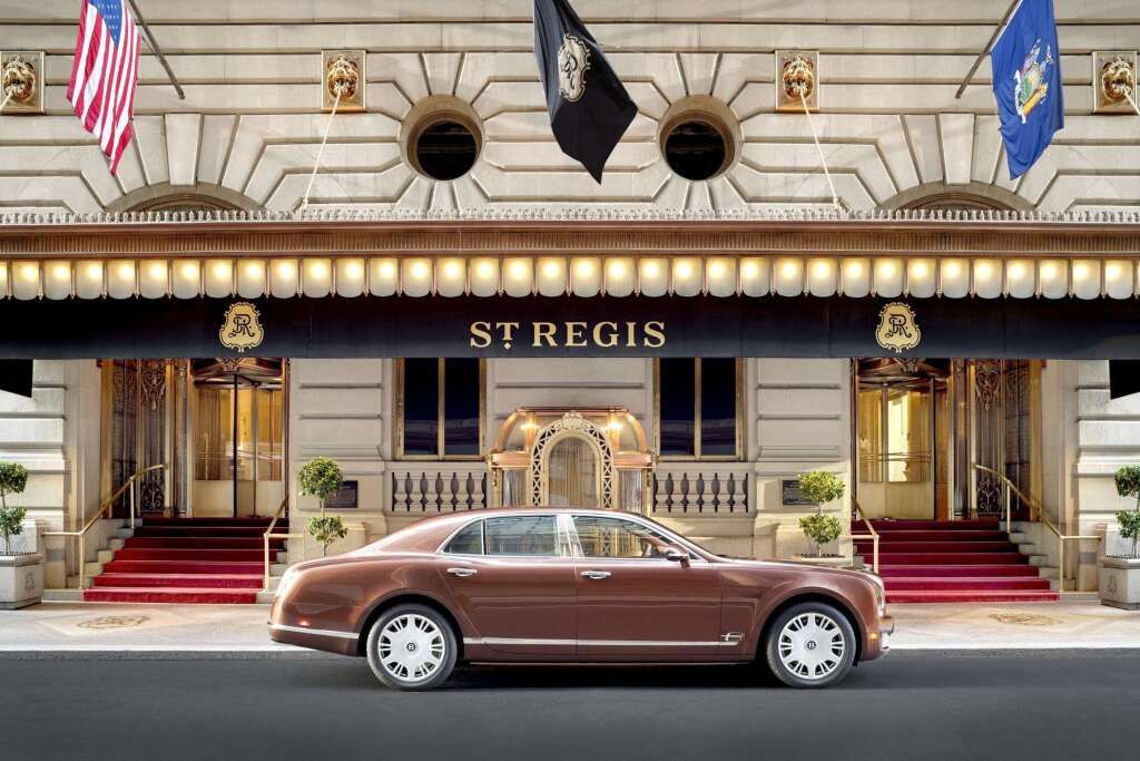 Elegante Außenansicht des St. Regis New York mit luxuriösem Auto im Vordergrund.
