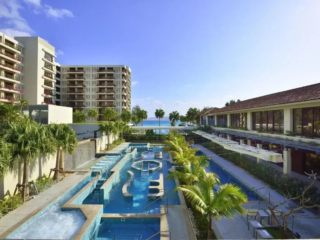 Luxuriöser Poolbereich mit Palmen und Meerblick