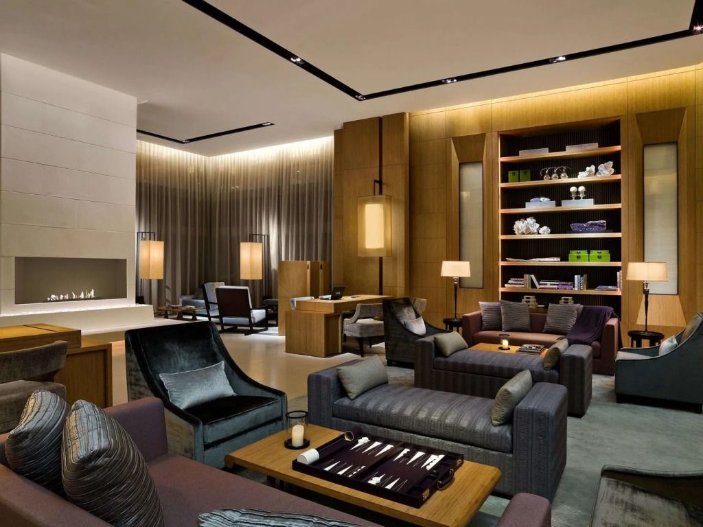 Elegante Lounge im Upper House mit moderner Einrichtung und Bücherregal.