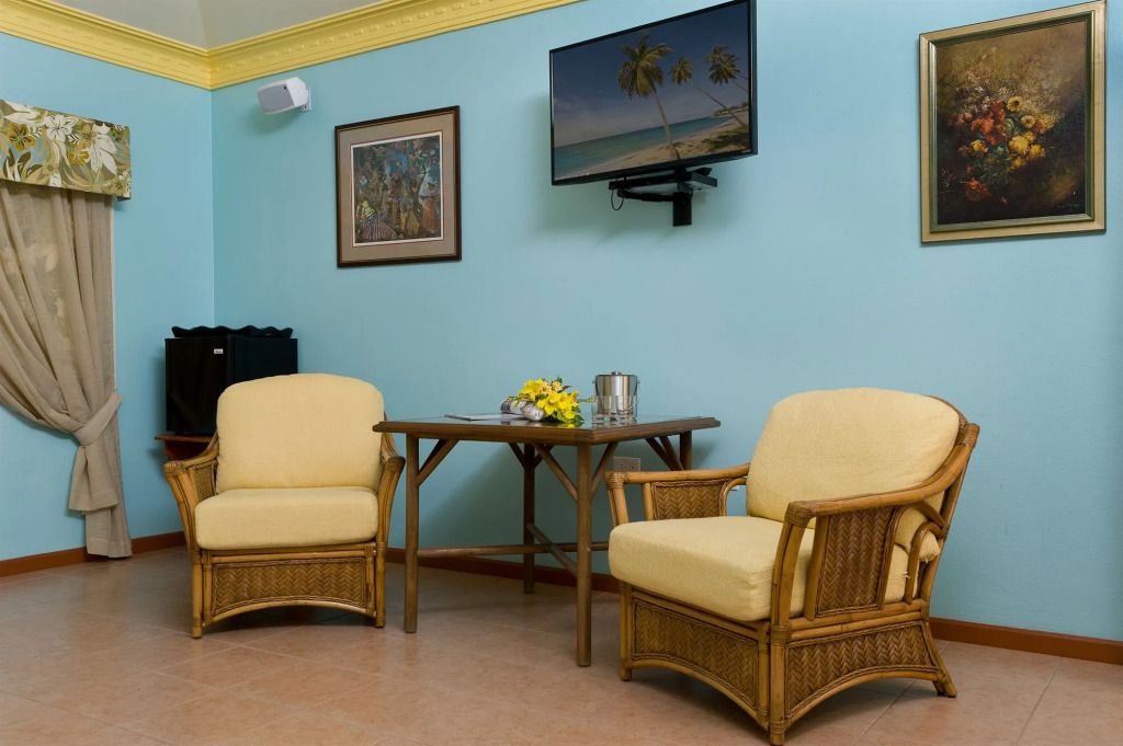 Gemütliche Sitzecke mit Korbstühlen und Tropenbild