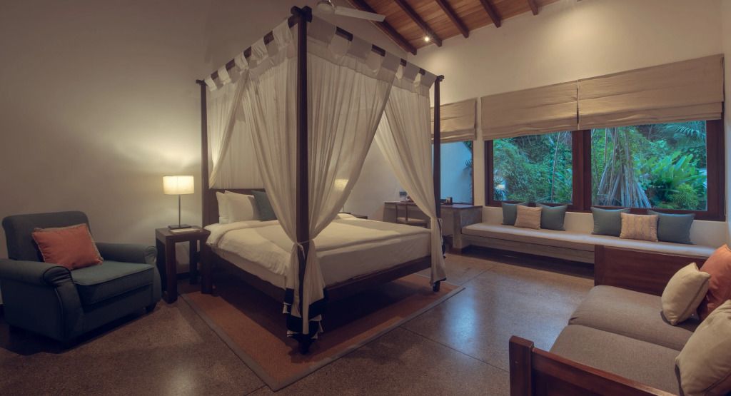 Geräumiges Zimmer mit Himmelbett und gemütlicher Sitzecke