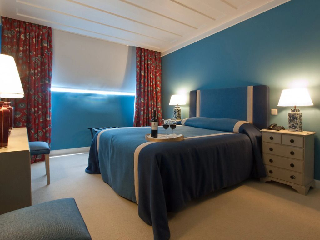 Elegantes Zimmer mit blauem Farbkonzept und floralem Vorhang.