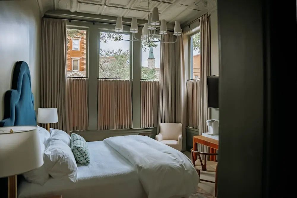 Helles Zimmer mit großen Fenstern und stilvoller Einrichtung.