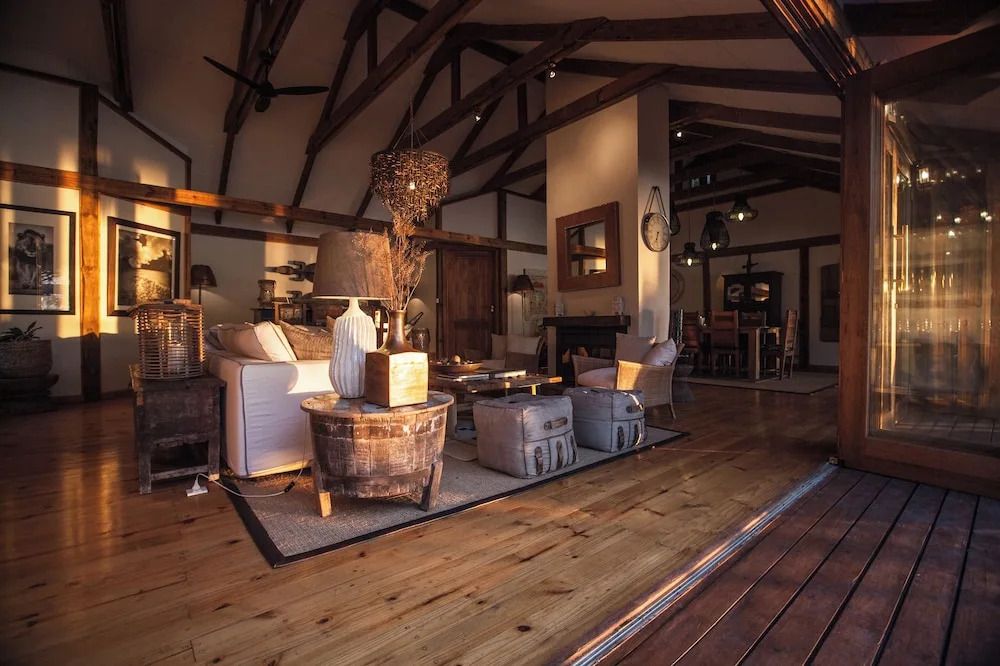 Gemütliche Lounge mit rustikalem Design und Holzboden in der Tongabezi Lodge