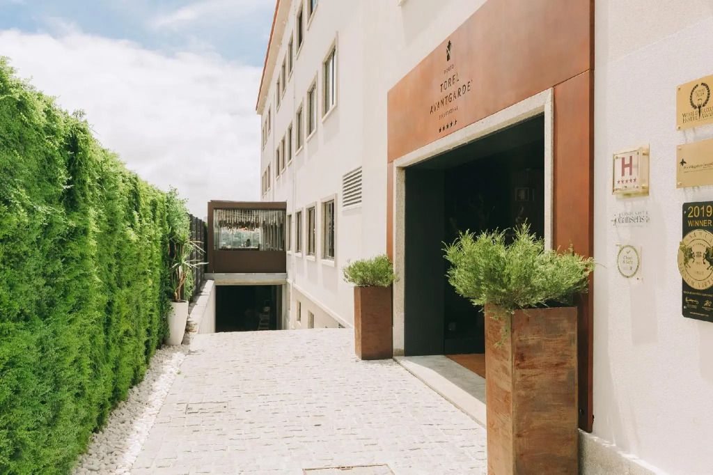 Elegante Hotelfassade mit modernen Design-Elementen und grünem Sichtschutz