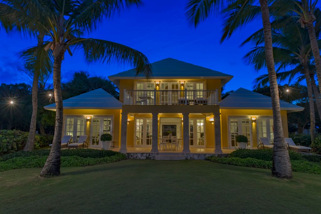 Beleuchtete Villa umgeben von Palmen bei Nacht im Tortuga Bay Hotel