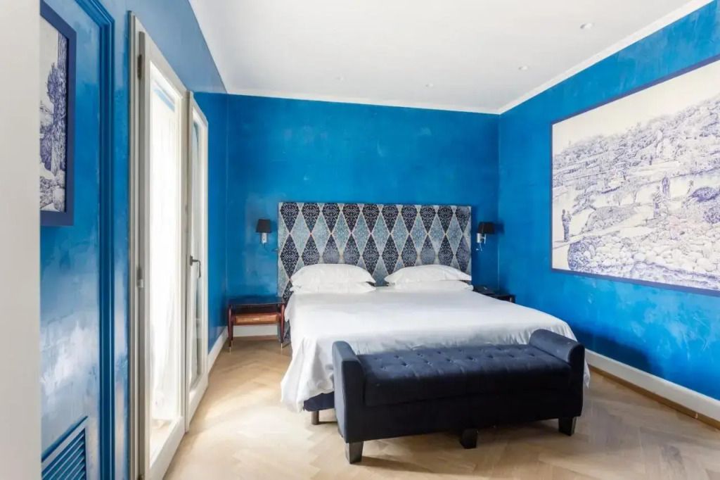 Helles Zimmer mit blauem Wandanstrich und stilvollem Kopfteil