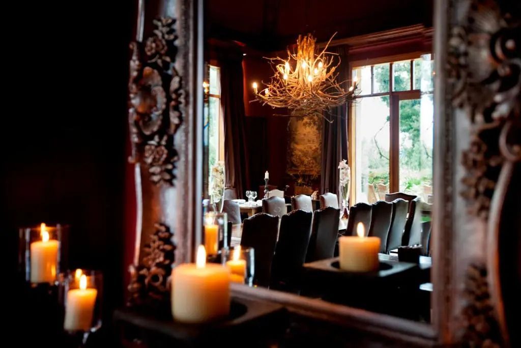 Eleganter Speisesaal mit Kerzenlicht und großem Fenster im Hintergrund