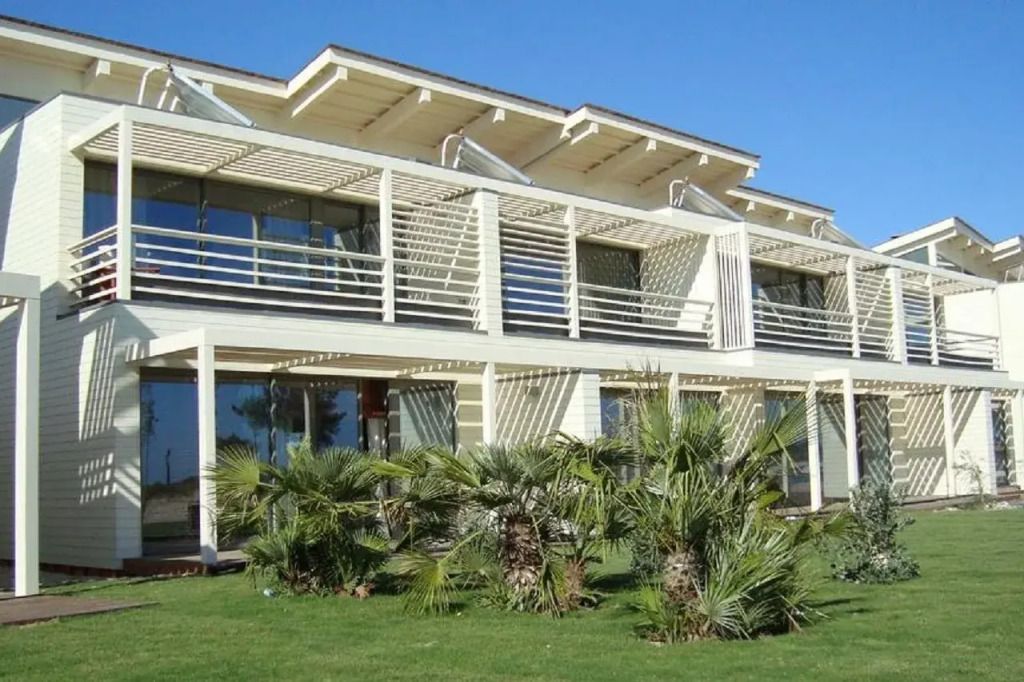 Moderne weiße Fassade mit Palmen im Garten