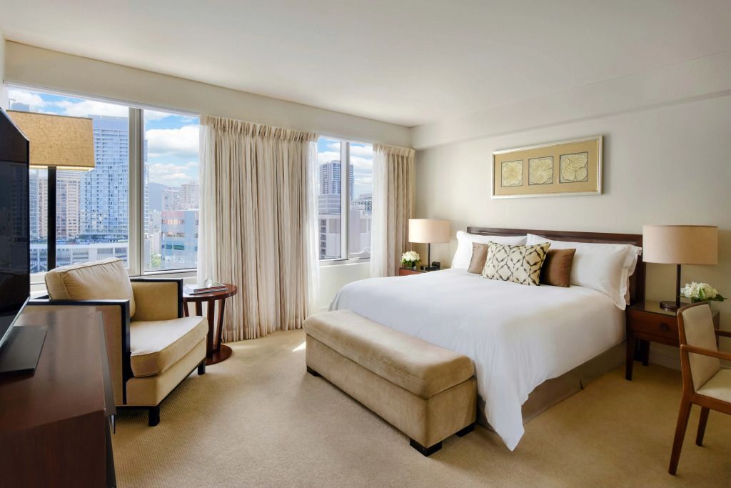 Helles Hotelzimmer mit großem Bett und Stadtblick