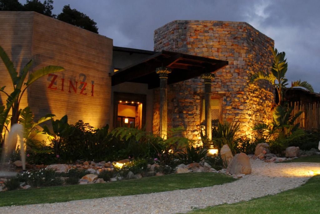 Abendliche Außenansicht des Tsala Treetop Lodge aus Stein und Holz mit Beleuchtung