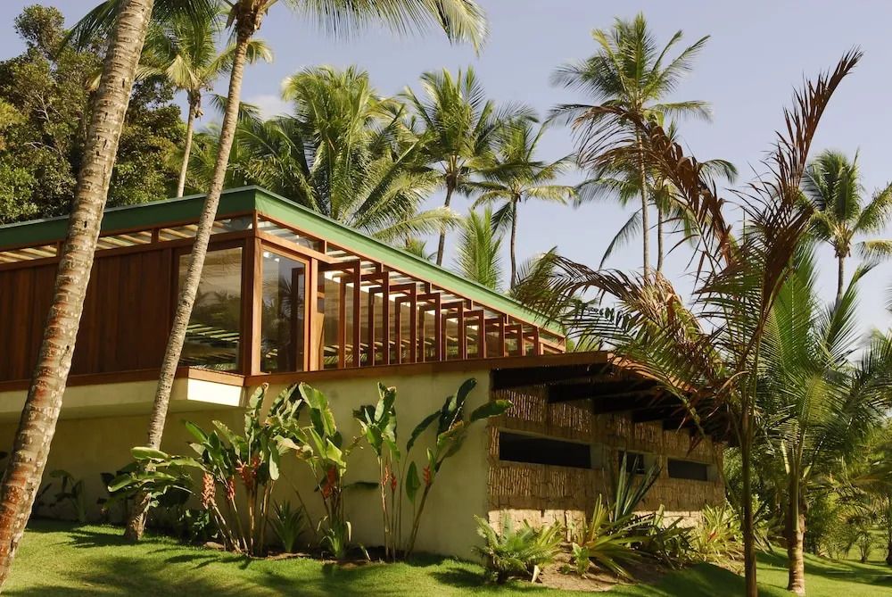 Tropischer Bungalow umgeben von Palmen und üppiger Vegetation