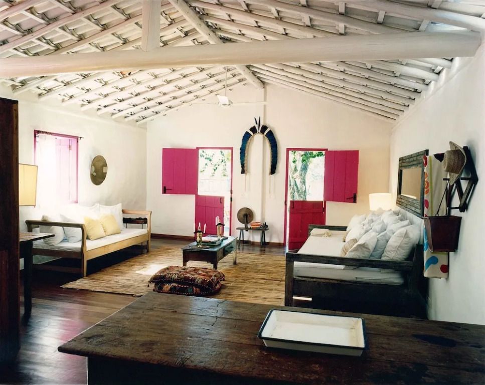 Helles Wohnzimmer mit rustikalen Elementen und roten Türen