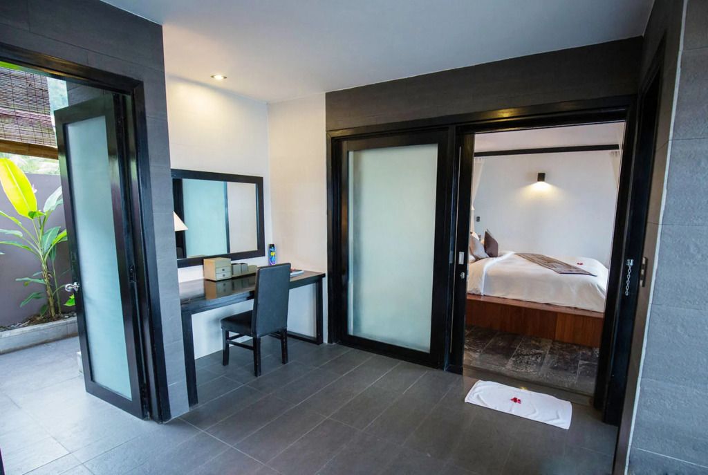 Elegantes Hotelzimmer mit Schreibtisch und Blick ins Schlafzimmer