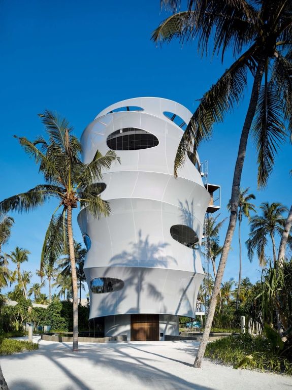 Eine moderne und markante Architekturstruktur umgeben von Palmen auf der Malediveninsel.