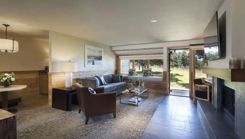 Geräumiges Wohnzimmer in einer Suite mit Blick auf die Natur und moderner Einrichtung.