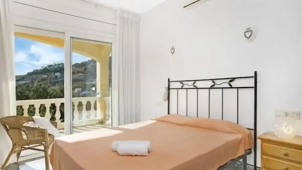 Helles Schlafzimmer mit einem großen Bett und Blick auf die Terrasse