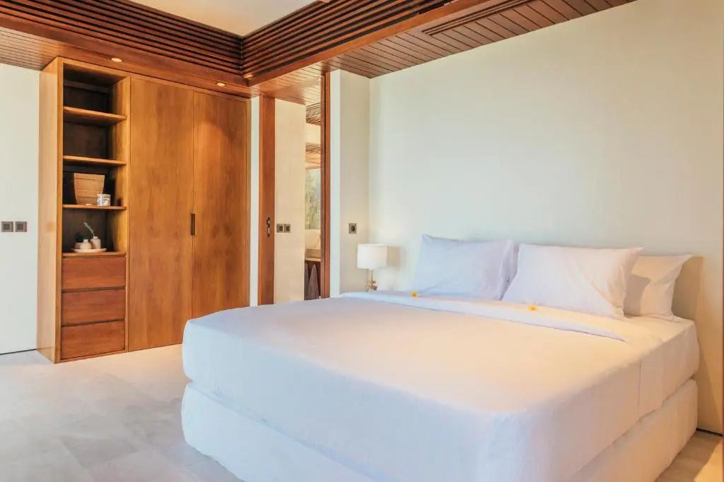 Elegantes Schlafzimmer mit Holzakzenten und großem Bett in heller Umgebung