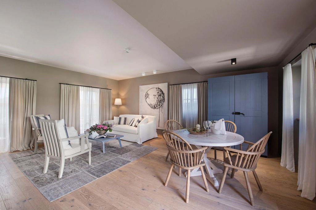 Elegante Lounge mit weißem Sofa und Holzmöbeln im Hotel Meneghetti