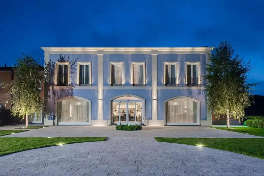 Elegante Fassade des Villa Neri Resorts bei Nachtbeleuchtung