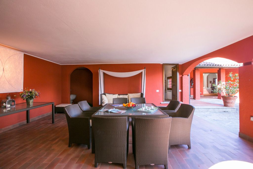 Überdachte Gartenlounge mit Esstisch und Sitzgelegenheiten in modernem Design.