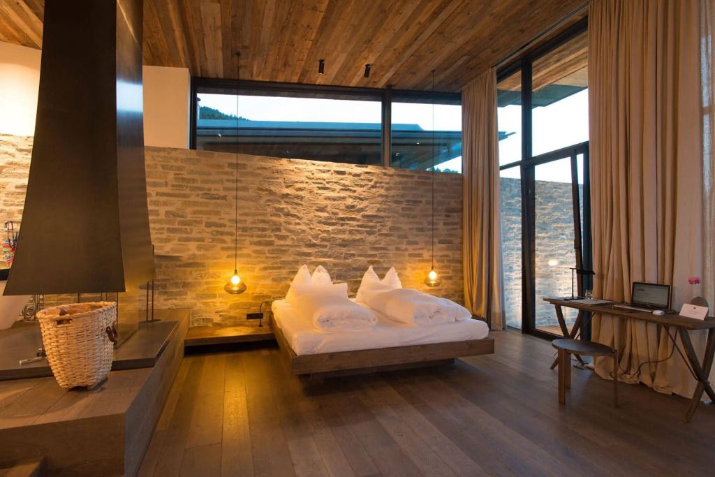 Elegantes Zimmer mit Doppelbett und Wand aus Naturstein im Hotel Wiesergut.