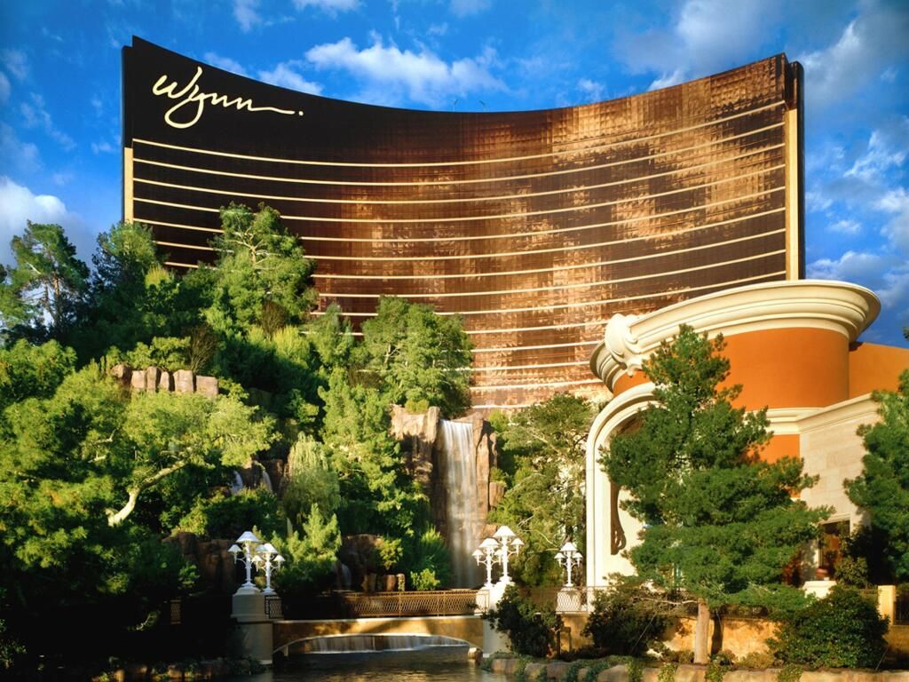 Außenansicht des Hotels Wynn Las Vegas mit Wasserkaskade und üppiger Vegetation