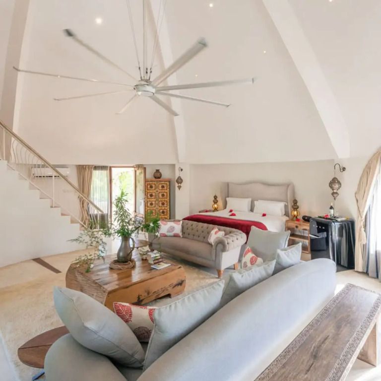 Luxuriöse Suite mit großem Bett, hellem Dekor und gemütlicher Sitzecke