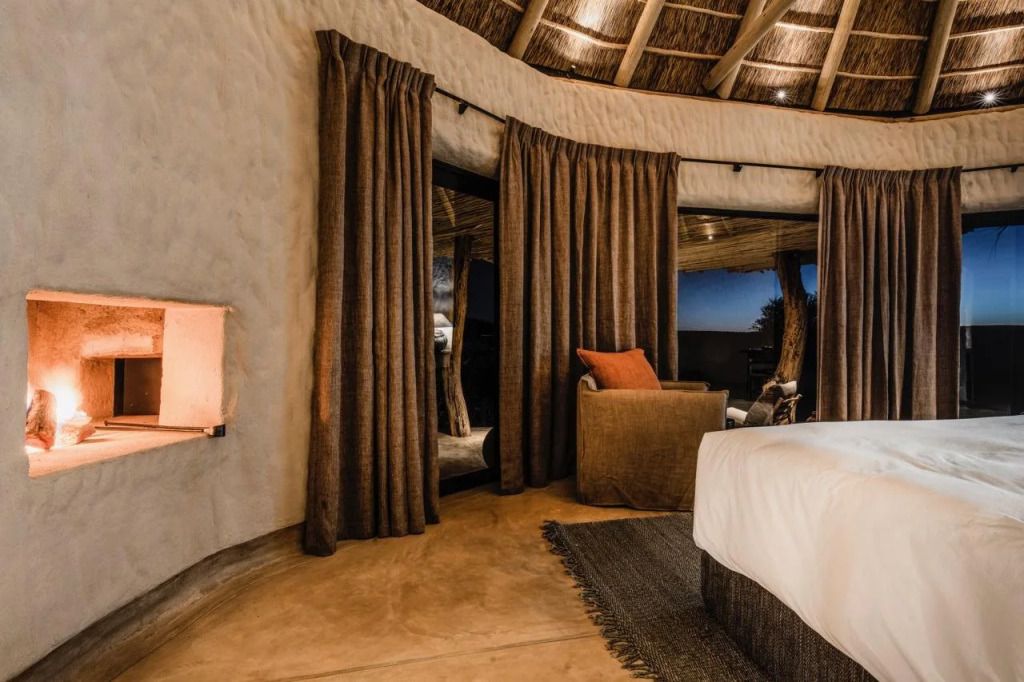 Luxuriöses Schlafzimmer mit afrikanischem Design Holzdach und großen Vorhängen.