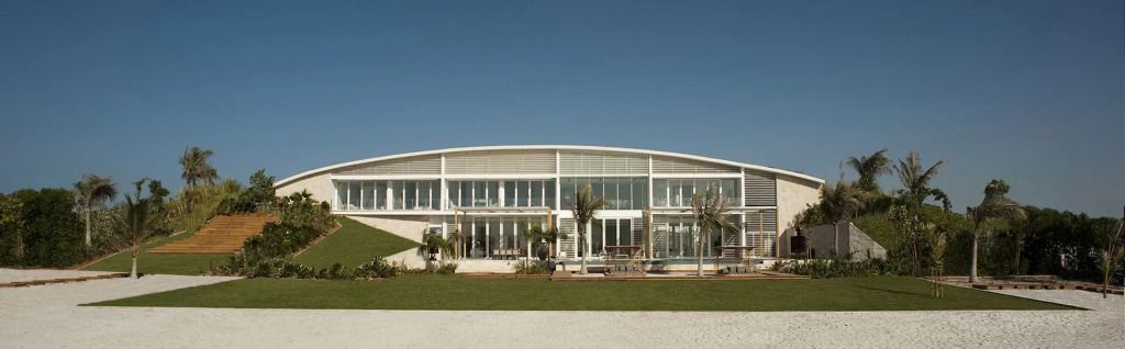 Moderne gläserne Hotel-Fassade mit Palmen im Vordergrund